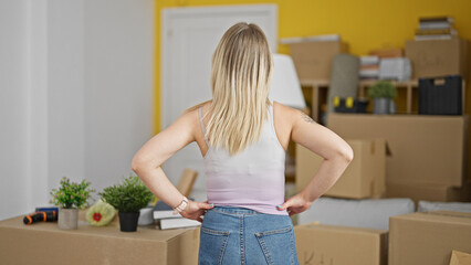 Poster - Young blonde woman standing backwards looking around at new home