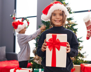 Poster - Adorable boys decorating christmas tree holding gift at home