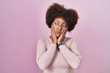 Poster - Young african american woman standing over pink background tired hands covering face, depression and sadness, upset and irritated for problem