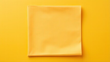 Wall Mural - top view with yellow empty kitchen napkin isolated on table background. Folded cloth for mockup with copy space, Flat lay. Minimal style.