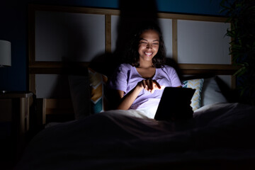 Poster - Young african american woman using touchpad sitting on bed at bedroom