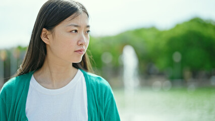 Sticker - Young chinese woman looking to the side with serious expression at park