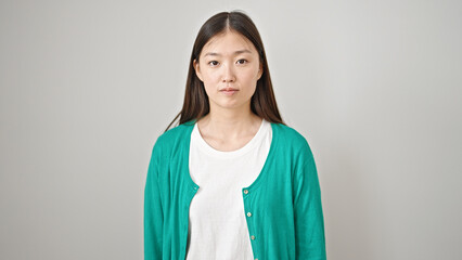 Sticker - Young chinese woman standing with serious expression over isolated white background