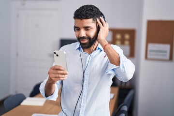 Poster - Young arab man business worker listening to music at office