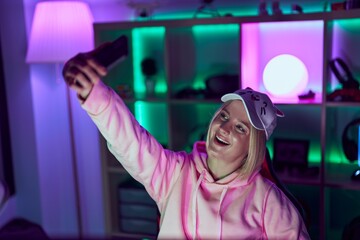 Poster - Young blonde woman streamer make selfie by smarpthone at gaming room