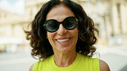 Wall Mural - Middle age hispanic woman smiling confident wearing sunglasses at the street