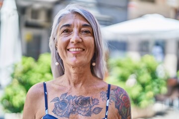 Wall Mural - Middle age grey-haired woman smiling confident standing at street