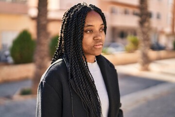 Poster - African american woman looking to the side with serious expression at park