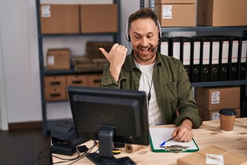 Sticker - Middle age caucasian man working at small business ecommerce wearing headset pointing thumb up to the side smiling happy with open mouth