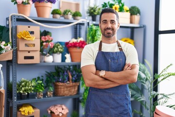 Canvas Print - Young hispanic man florist smiling confident standing with arms crossed gesture at florist