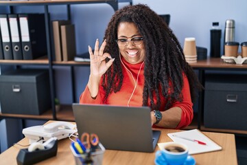 Poster - Plus size hispanic woman working at the office with headphones doing ok sign with fingers, smiling friendly gesturing excellent symbol