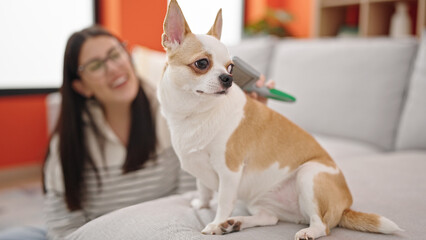 Canvas Print - Young hispanic woman with chihuahua dog sitting on the floor brushing dog hair at home