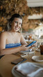 © Krakenimages.com - Young hispanic woman smiling happy using smartphone sitting on the table at the restaurant