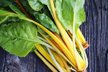 Wall Mural - Fresh raw swiss rainbow chard leaves on wooden background. Top view