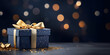 Blue gift box with a gold ribbon and a gold bow on a table on a black background