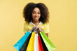 Portrait smiling beautiful African American woman holding colorful shopping bags looking at camera