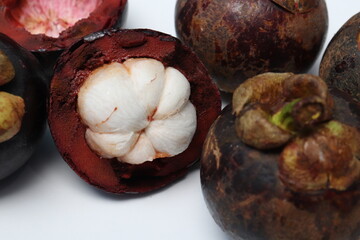 
Fresh ripe mangosteen fruit, white on the inside and brown or purple on the outside. The taste is sweet and refreshing. Isolated white background.