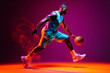 © ckybe - In action: A portrait of a dedicated African-American basketball player training under neon lights against a pink backdrop.