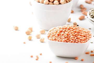 Wall Mural - Closeup of raw red lentils in bowl on white background