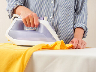 Wall Mural - A girl irons clothes with an iron, household chores, clothing care