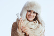 © Alliance - smiling modern woman in winter coat and fur hat on white