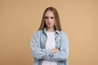 © New Africa - Resentful woman with crossed arms on beige background
