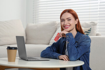 Canvas Print - Happy woman with credit card near laptop at home, space for text. Online shopping