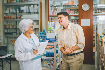 Wall Mural - pharmacist is asking about a patient's condition in order to prescribe medication according to the patient's symptoms who come for prescription consultation in a modern pharmacy.