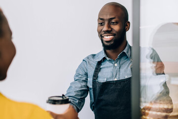 Canvas Print - Salesman giving takeaway coffee to customer in confectionery shop