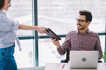 Wall Mural - positive cheerful man dressed in casual wear sitting at company desktop with modern laptop computer