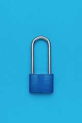 Closed blue metal lock on a blue background.