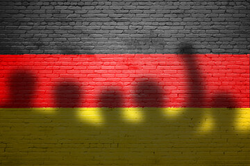 The refugees migrate to Germany . Silhouette of illegal immigrants . Europe union migration policy. Germany flag painted on a brick wall with protesters