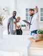© BullRun - Confident estate agent showing kitchen to African American pleased hugging couple