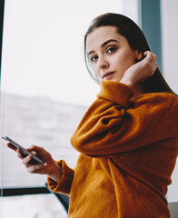 Wall Mural - attractive woman with mobile phone posing indoors