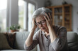 © toonsteb - Sick old woman having a headache in the living room during the daytime