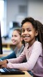 Portrait of a girl learning to code, with a softly blurred friend in the background in a computer lab