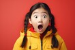 Portrait of surprised asian girl on bright colors studio backgroud, excitement and fascination, shocked and amazed kid with unexpected thing happen
