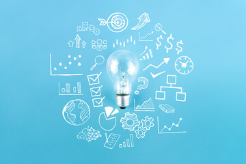 Wall Mural - Light bulb and business strategy on blue background. Concept of idea, innovation and Inspiration