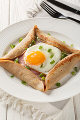 Canvas Print - Homemade buckwheat crepe galette with egg, ham and green onion closeup on the plate on the table. Vertical