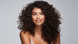 © Malambo/Peopleimages - AI - Portrait of young woman with dark natural curly hair. Hair care, make-up and hair health