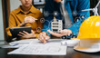 © Nuttapong punna - Engineer teams meeting working together wear worker helmets hardhat on construction site in modern city.Asian industry professional team with VR icon