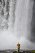 View Of A Person Standing In Front Of Skogafoss.Waterfall Along The Skoga River In The South Of Iceland.