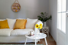 Living Room With White Sofa, Sunflowers And Cup On Table At Home