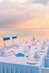 Wall Mural - Wedding set up, romantic sunset beach table, luxury destination dining. Elegant table setup in blue pastels for a beach wedding sea sky view. Love couple best honeymoon party. Romance island landscape