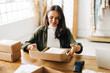 © (JLco) Julia Amaral - Running an ecommerce small business: Female drop shipper fulfilling orders for her online store