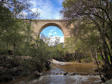 Ponte Antiga Sobre O Rio Tinhela Em Murça, Portugal. Água A Correr Rio Abaixo E Pela Antiga Ponte De Pedra A Meio De Uma Floresta.