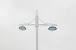 © ADDICTIVE STOCK - Minimalist dual-headed streetlight against clear sky