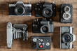 © OlegD - Set of vintage film camera from the times of the USSR on a wooden background, closeup, top view. Line of old retro cameras