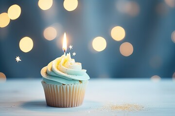 Poster - Candle lit birthday cupcake on gray table with blurred lights Text space available