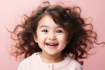 Healthy happy funny smiling face of a little Asian girl on a pink background